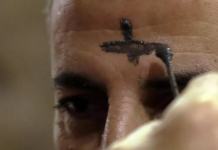 Chrześcijański kapłan maronicki nanosi krzyż popiołem na czole libańskiego mężczyzny w kościele w nadmorskim mieście Jbeil